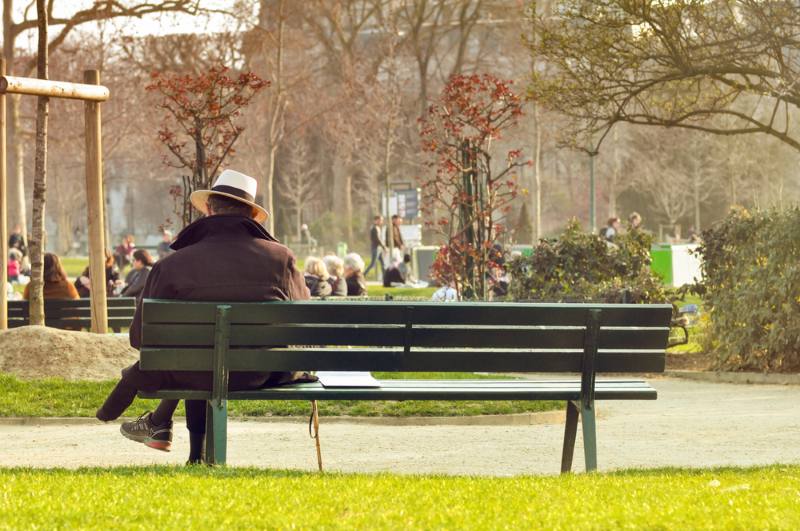 man sitting alone on bench at the park