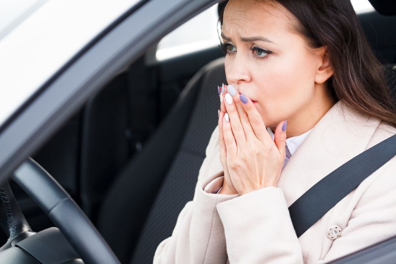 woman looks stressed and worried in car