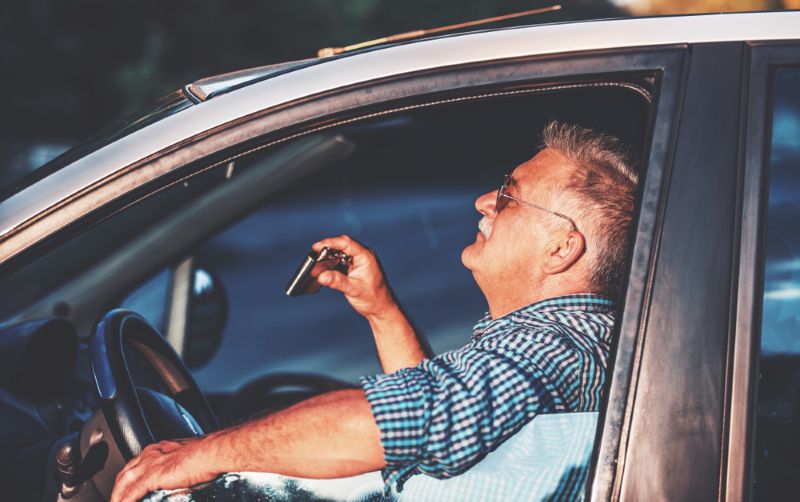 sipping on a flask of alcohol while driving during sunset