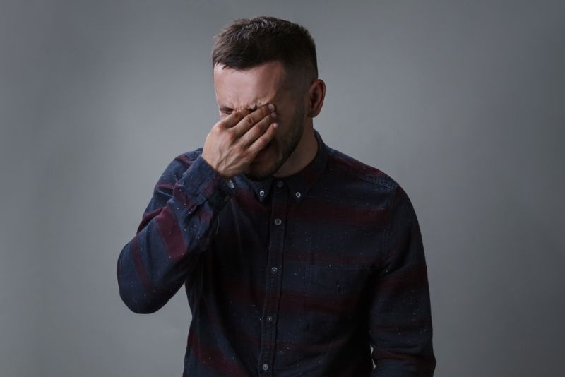 Disappointed man grabbing his forehead in disbelief