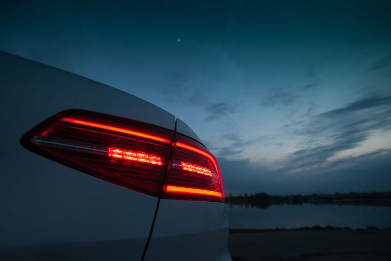 Closeup image of a car's brake light in the evening