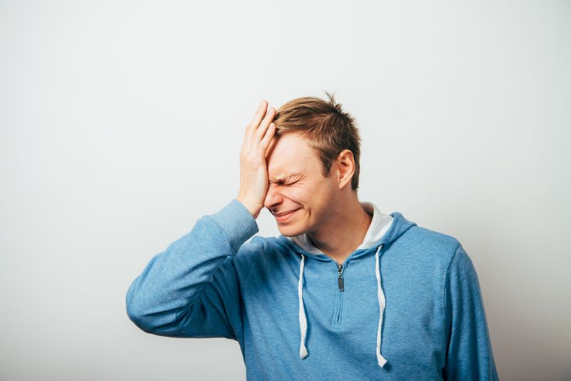 Disappointed man smacking himself in the head