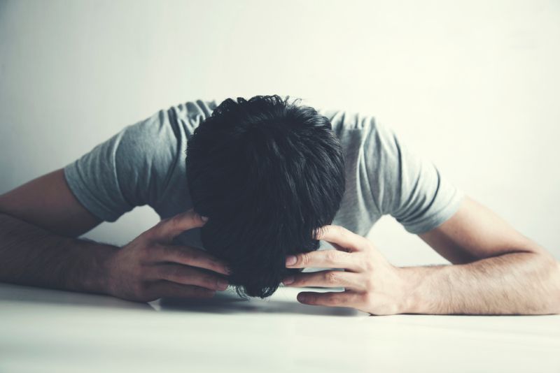 Disappointed man holding his head in his hands