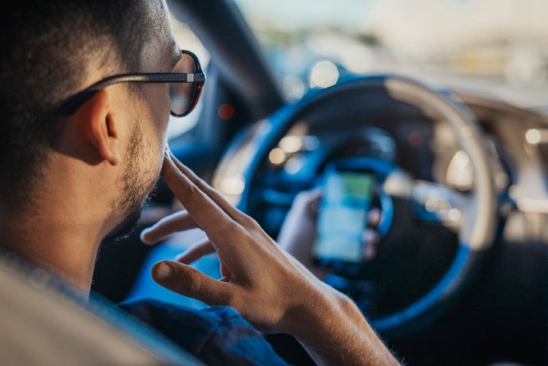 Man using his cellphone while sitting in car
